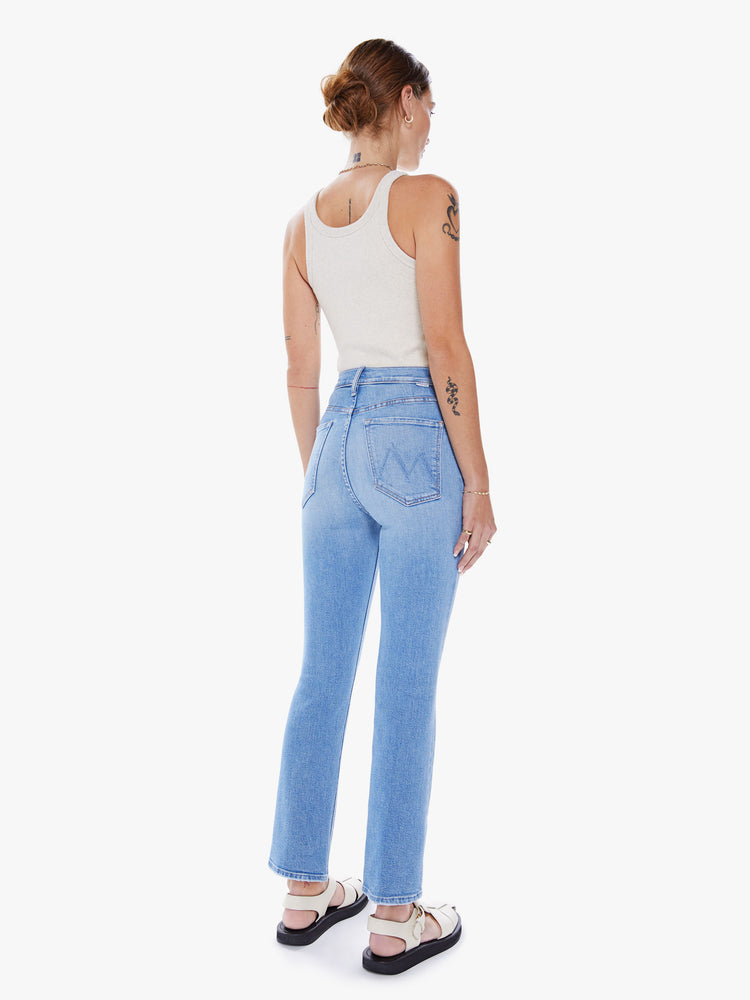 Back view of a woman ultra high-rise flare jean with a button fly and a clean ankle-length hem in a light blue wash.