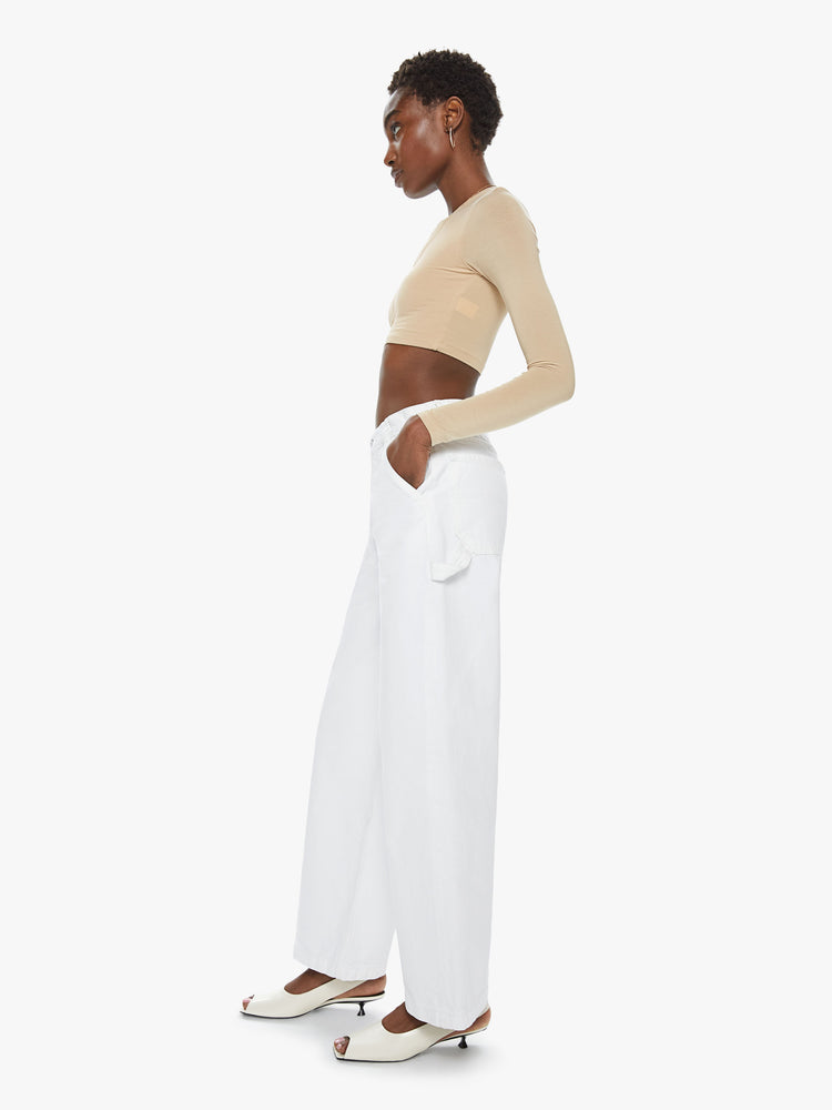 Side view of a women's white wide leg utility style jean. This style is inspired by the fit of 90s jeans.