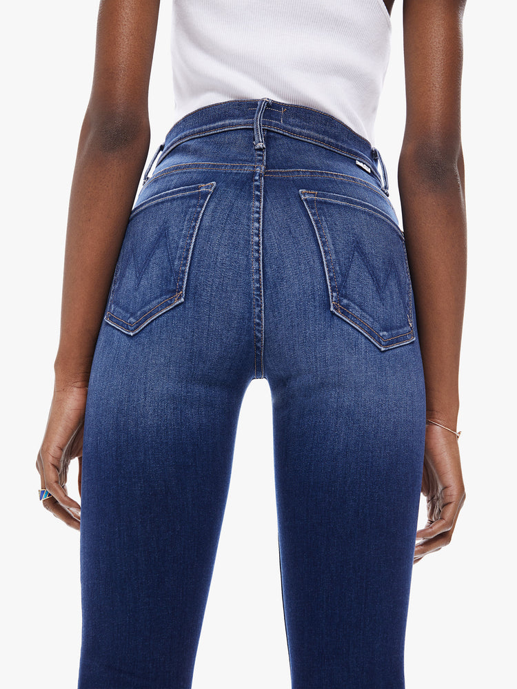 Back detail view of women's deep blue bootcut jean with fading and a frayed ankle length hem