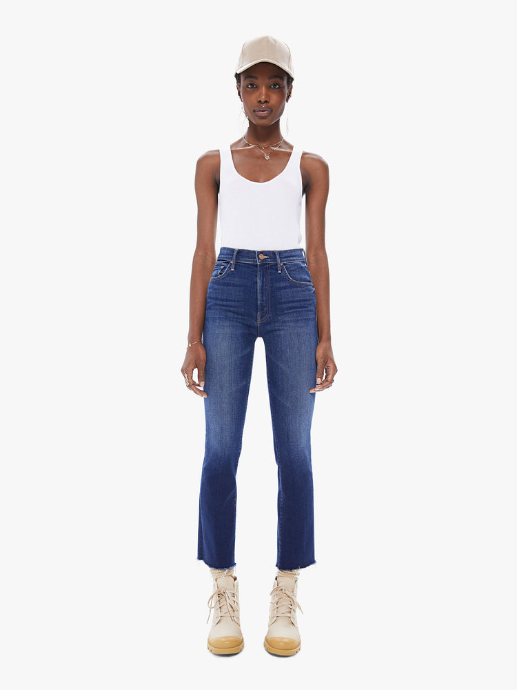 Front view of women's deep blue bootcut jean with fading and a frayed ankle length hem