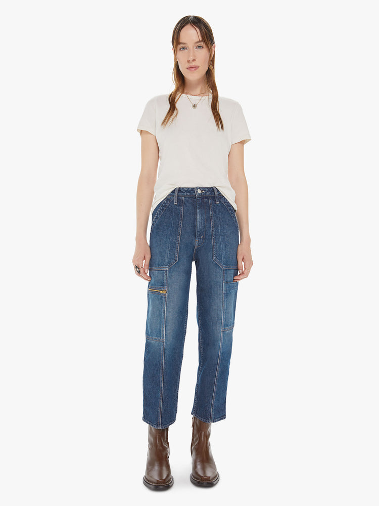 Front view of a womens dark denim wash jean featuring a high rise, cropped length, and cargo details.