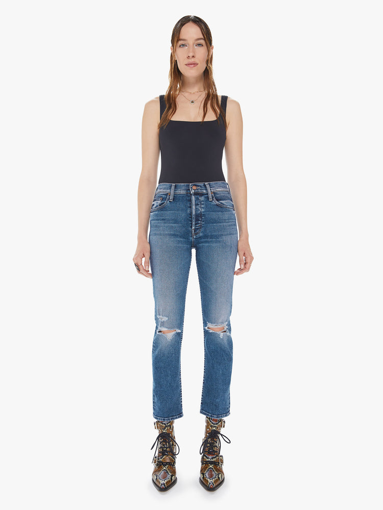 Front view of a womens medium blue wash jean featuring a high rise, an ankle length straight leg, and distressed details at the knees.
