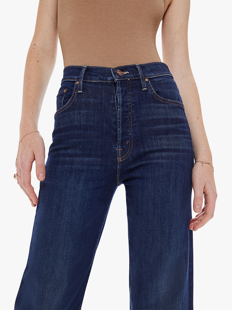Front detail view of a women's dark blue high rise straight leg jean with a clean ankle length hem