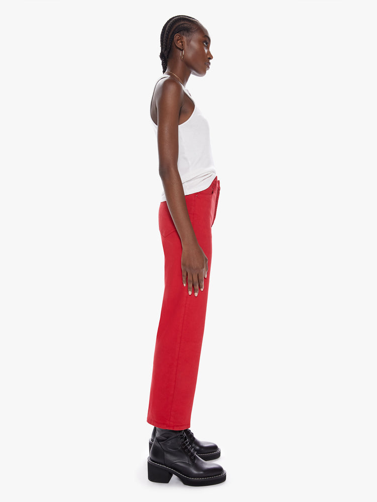 Side view of a womens bright red high waisted wide straight leg pant with an ankle length inseam and button fly.
