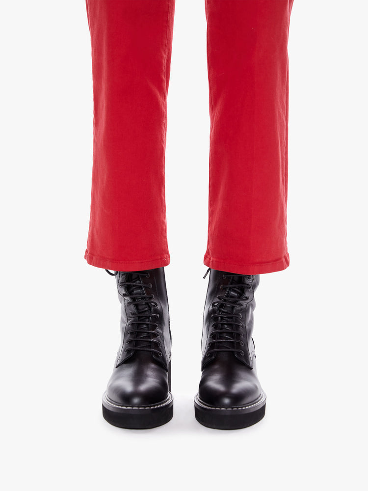Hem close up  view of a womens bright red high waisted wide straight leg pant with an ankle length inseam and button fly.