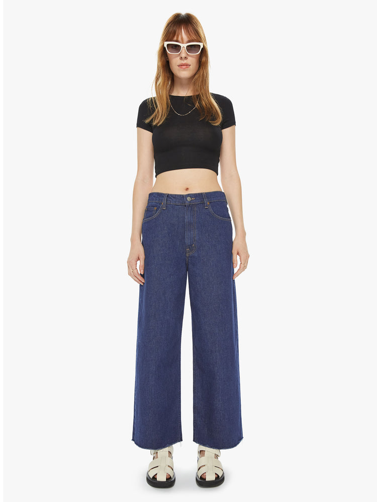 Front view of a women's dark blue wide leg jean with a slouchy fit at the waist and a frayed hem. This style is inspired by the fit of 90s jeans.