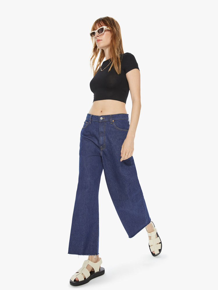Full front view of a women's dark blue wide leg jean with a slouchy fit at the waist and a frayed hem. This style is inspired by the fit of 90s jeans.