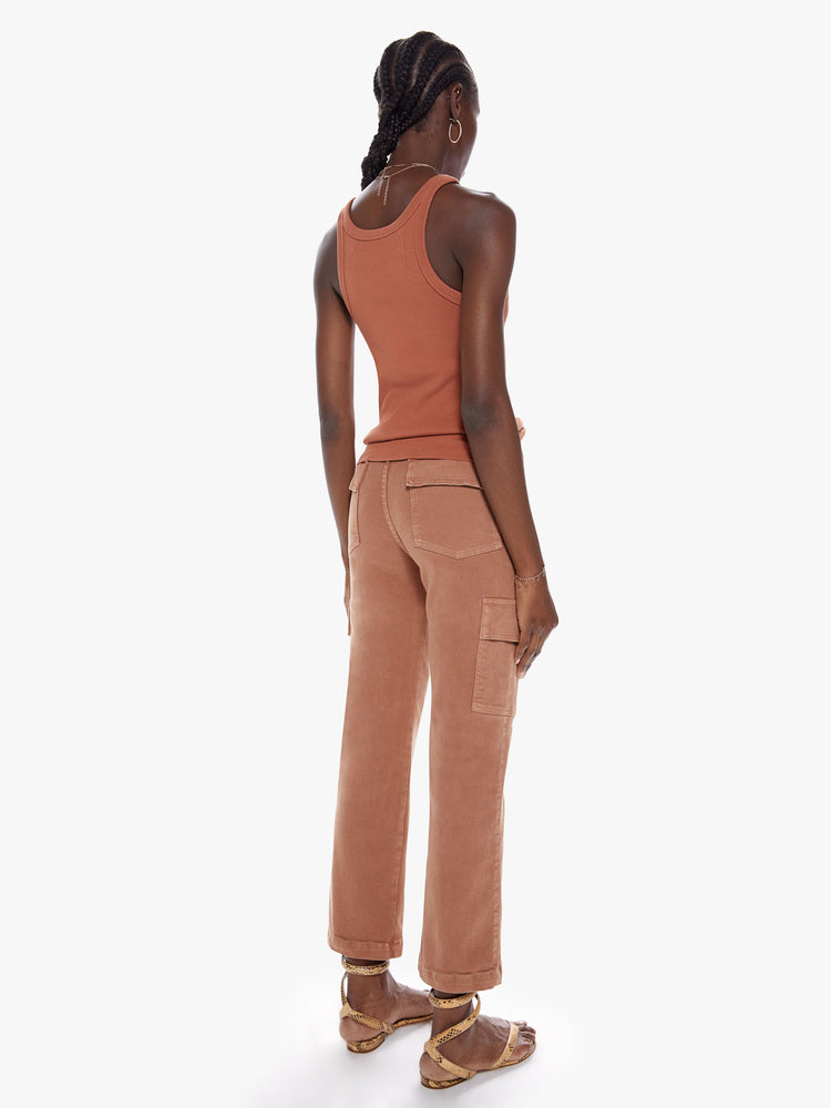 Back full body view of a woman in high waisted ankle length pants with a wide straight leg, button fly, cargo pockets and seams down the front made from a cotton blend with a touch of stretch in a faded rust hue with tonal hardware