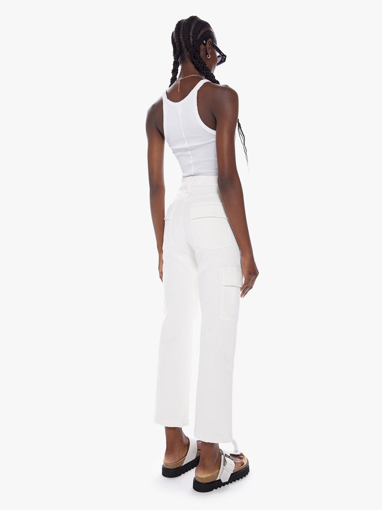 Back view of a woman High-waisted ankle-length pants with a wide straight leg, cargo pockets and seams down the front in an off white hue.