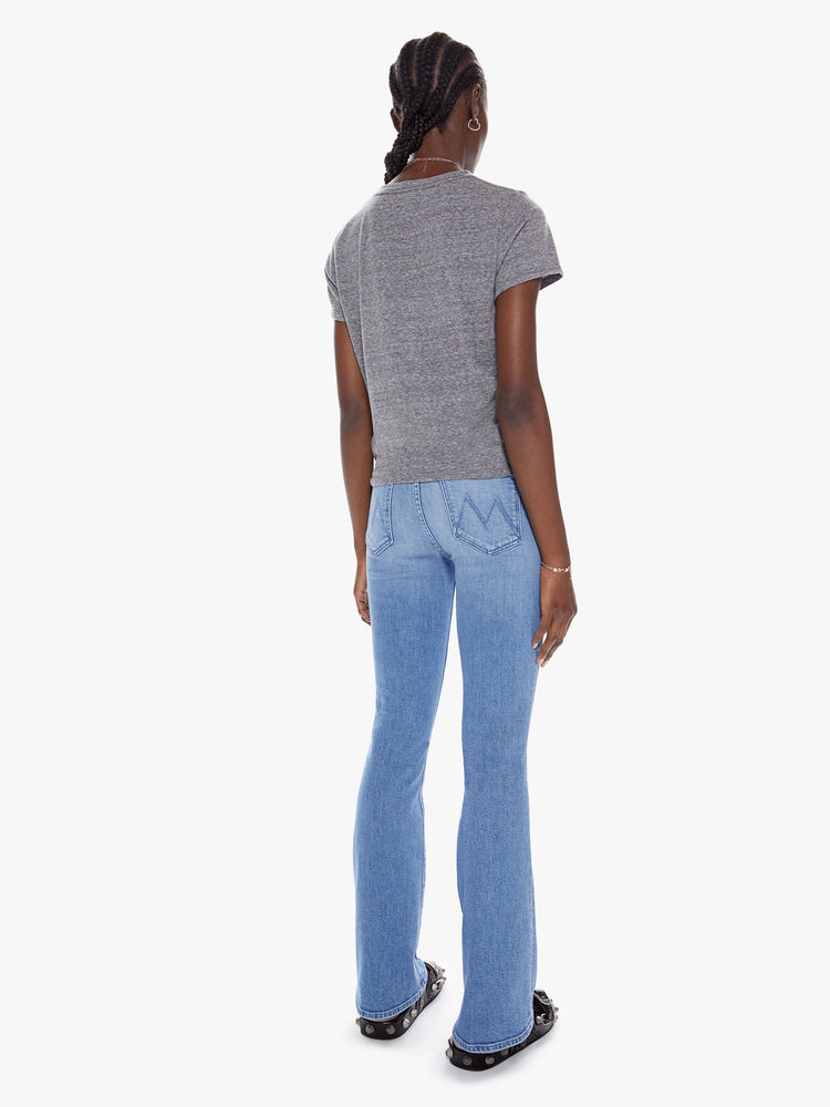 Back view of a womens medium blue wash jean with a high rise, flare leg, and clean hem.