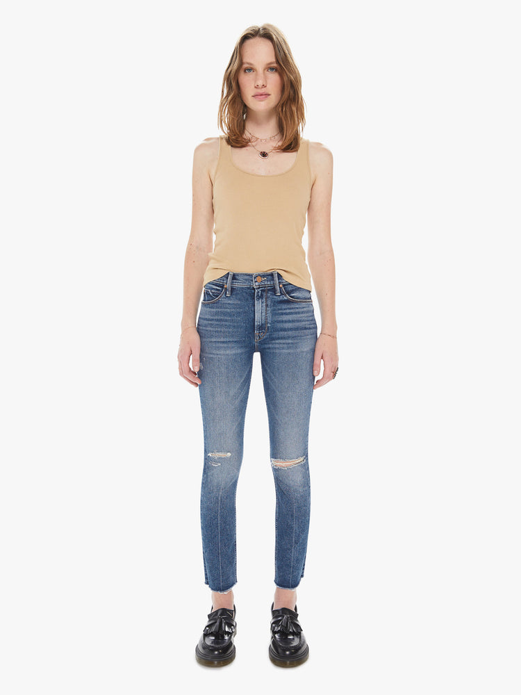 Front view of a women's medium blue mid-rise jean with a slim straight fit and a frayed ankle length hem