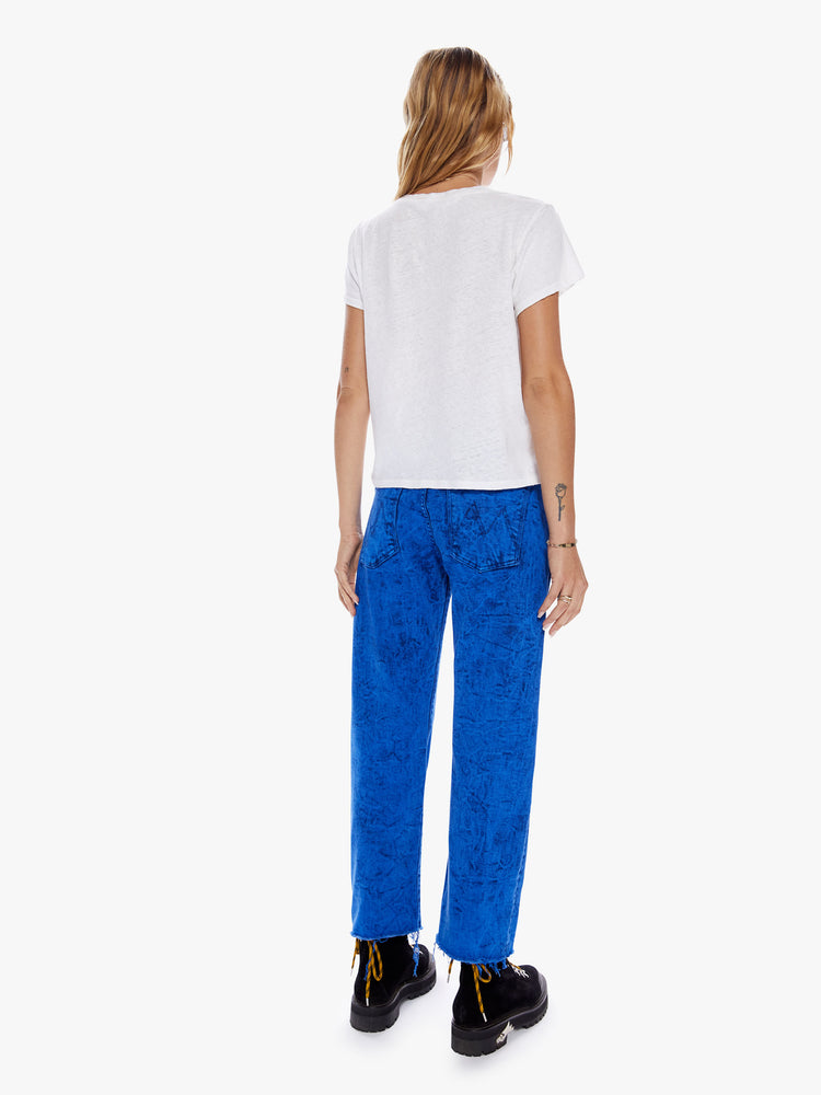 Back full body view of a woman in a cropped jean with a button fly, slouchy straight leg and relaxed fit that's designed to sit on the hips cut from denim with a touch of stretch in a bright blue hue with acid-washed details