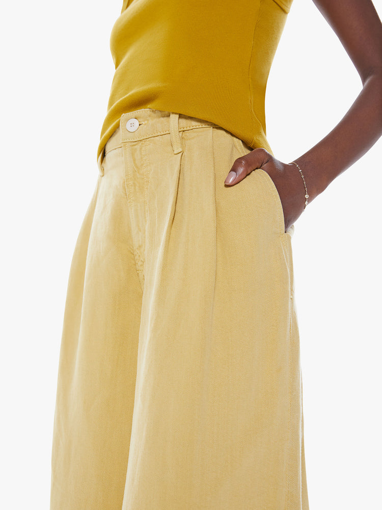 Close up view of high-waisted wide leg pant with a pleated waistband, back slit pockets, an ankle-length inseam and a clean, thick hem in a sunny yellow hue.