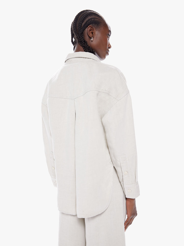 Back view of a woman workwear-inspired button up with drop shoulders, front patch pockets and a slightly curved hem in a creamy hue with tonal hardware for a monochrome look.