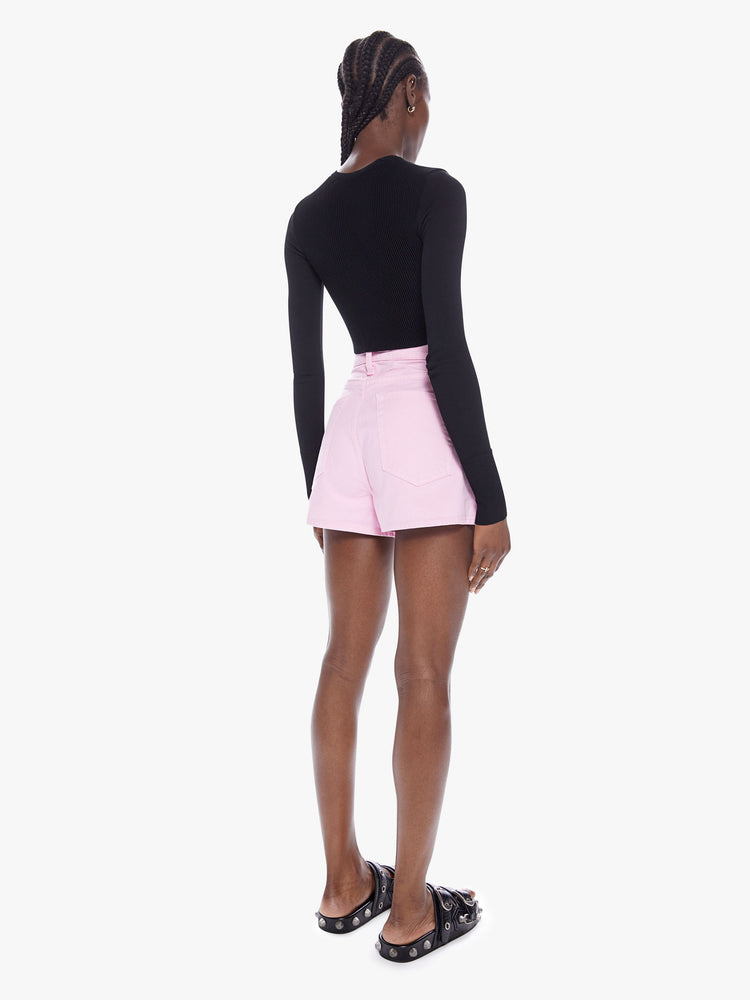 Back full body view of a woman in denim shorts from SNACKS from mothers homage to throwback styles of the 80s and 90s, the high rise shorts are designed with a super short inseam and a loose wide fit in a baby pink hue