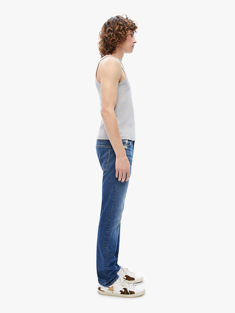Side view of men slim-straight leg with a mid rise, 32-inch inseam and a clean hem in a dark blue wash