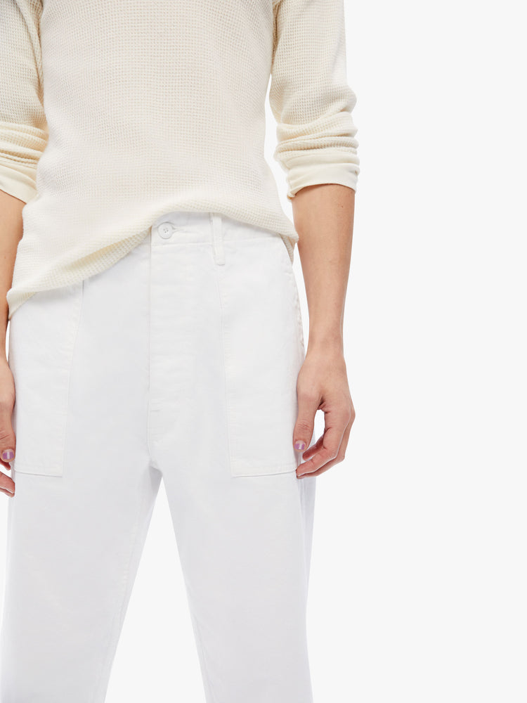 Close up  view of a mens military-inspired straight leg cargo pant with patch pockets and a cropped frayed hem in a bright white hue with tonal hardware.