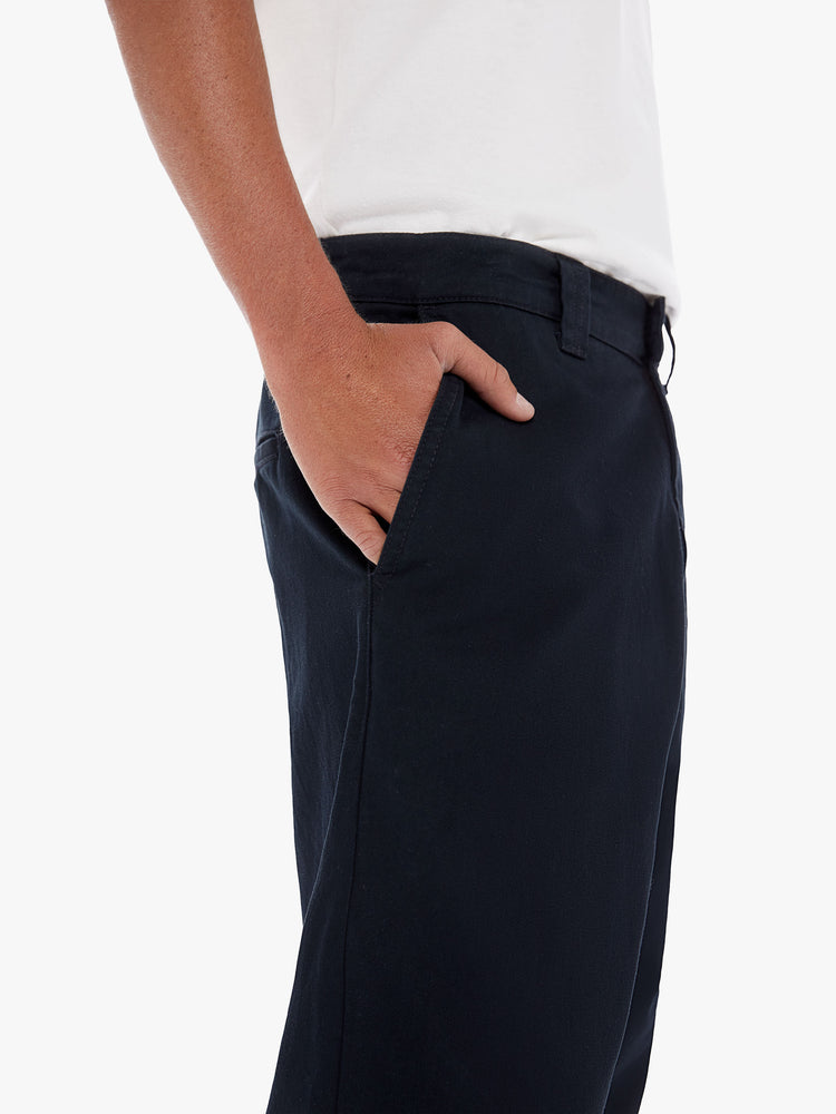 Pocket detail view of a men's black high waisted straight leg pant with a cropped hem