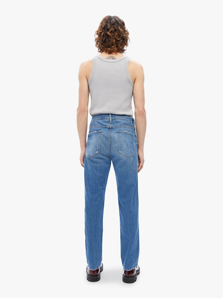 Back view of a men's straight-leg jean with a mid rise, ankle-length inseam and a clean hem in a mid blue wash with subtle whiskering,fading and distressed details