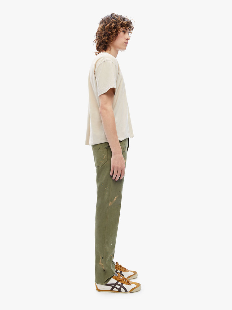 Side view of a mens classic pant with utilitarian pockets, a hammer loop and relaxed leg in an army green hue with paint splatters and tonal hardware.
