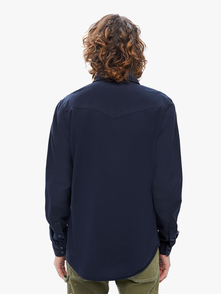 Back view of a mens classic Western-inspired shirt with snap buttons, flap patch pockets, long sleeves and a curved hem in a deep navy hue with tonal hardware.