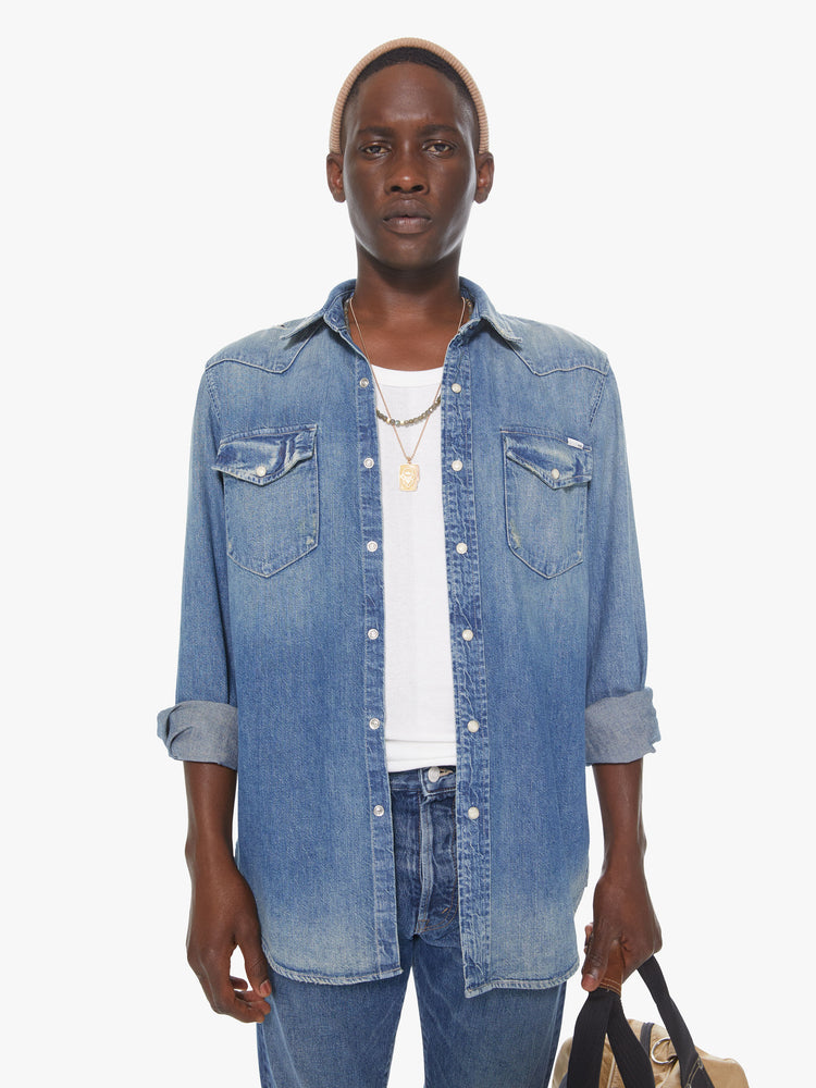 Front view of a men's faded denim blue shirt with snap buttons and patch pockets