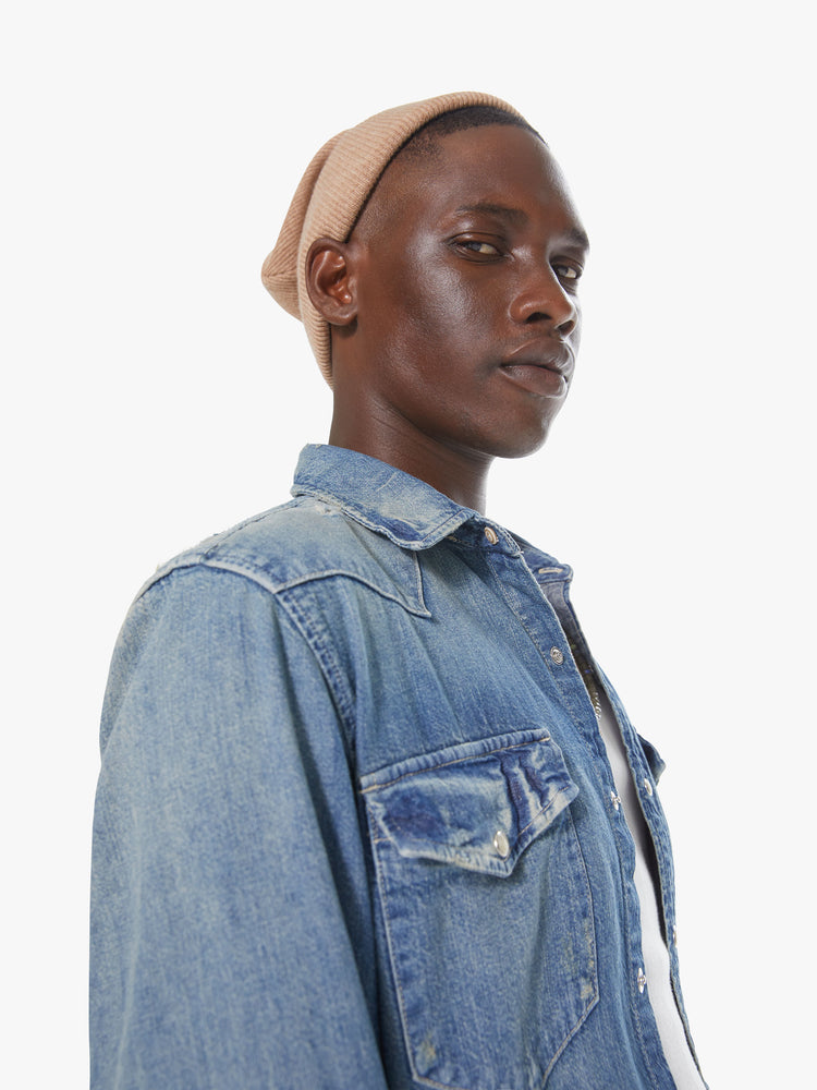 Front detail view of a men's faded denim blue shirt with snap buttons and patch pockets