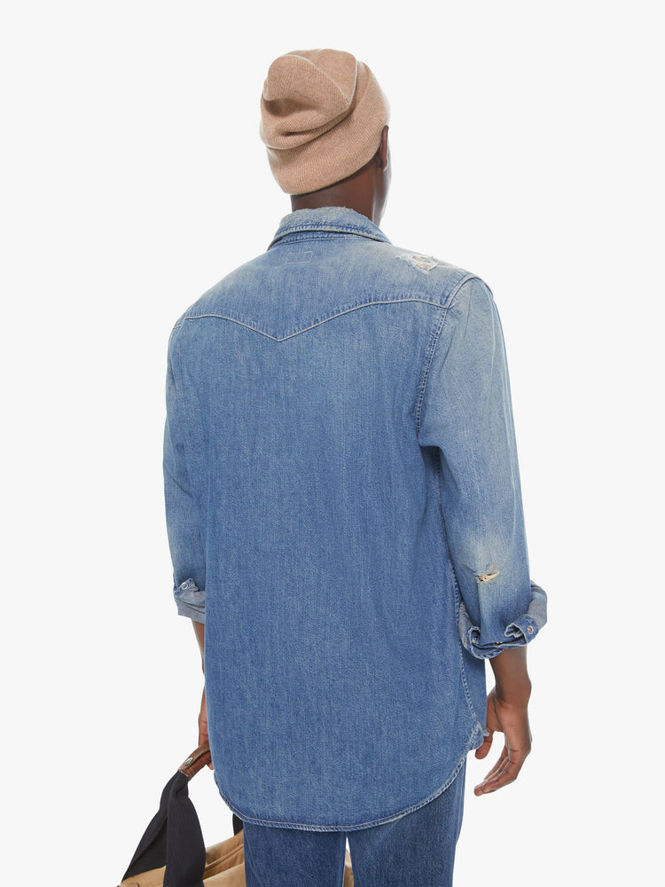 Back view of a men's faded denim blue shirt with snap buttons and patch pockets