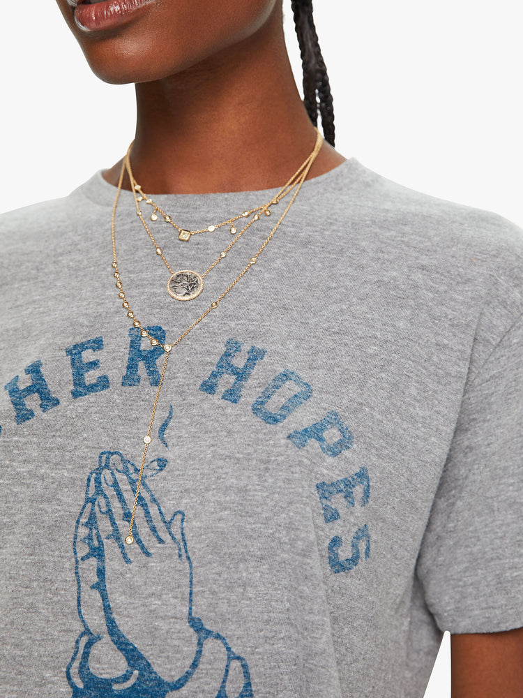 WOMEN close up detail front view of a woman in a heather grey unisex crew neck tee featuring a faded blue graphic of hands of the words "HIGHER HOPES".