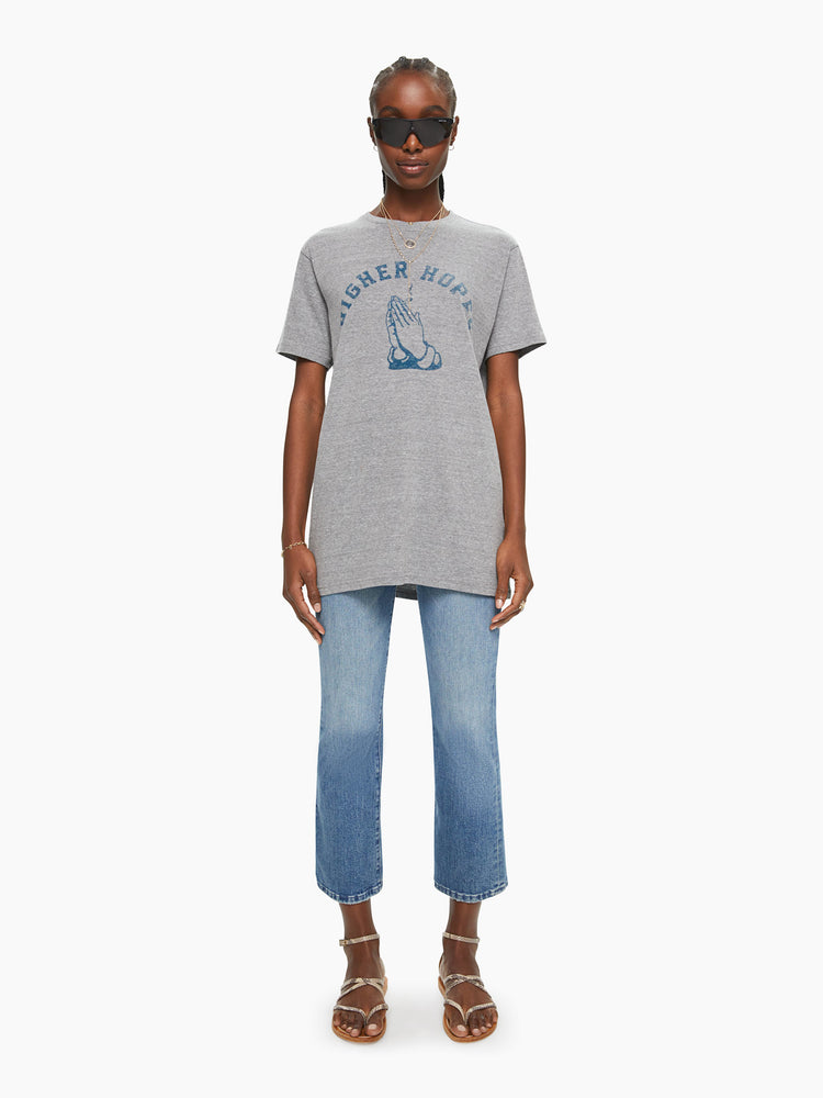 WOMEN front full body view of a woman in a heather grey unisex crew neck tee featuring a faded blue graphic of hands of the words "HIGHER HOPES".
