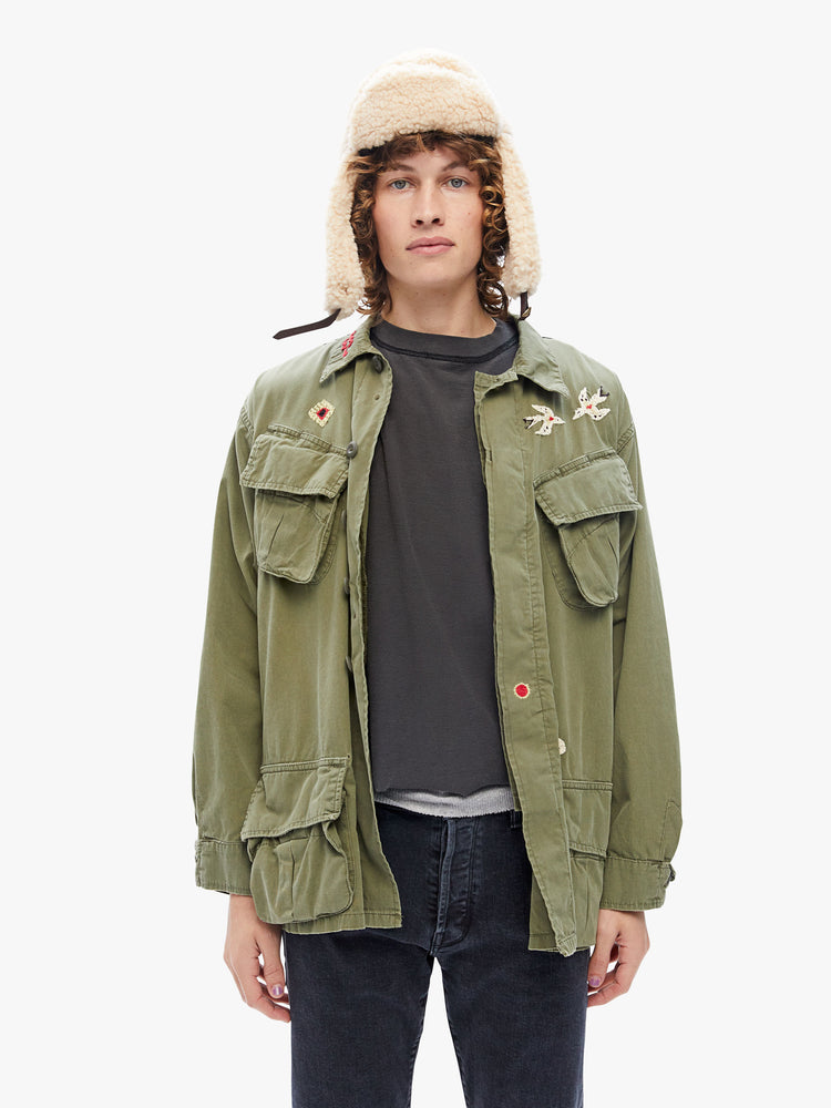 Front view a military-inspired jacket with a collar, front patch pockets and a boxy fit in an army green hue with embroidered details on the front and back.