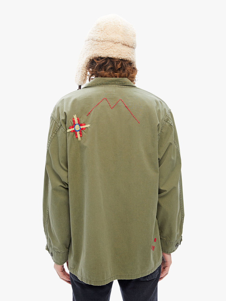Back view a military-inspired jacket with a collar, front patch pockets and a boxy fit in an army green hue with embroidered details on the front and back.