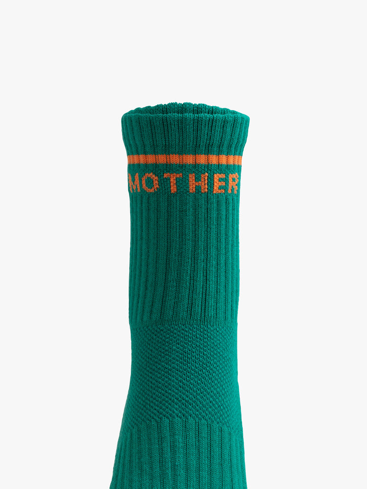 Close up view of a green sock with an orange stripe and the word "MOTHER" along the ankle.