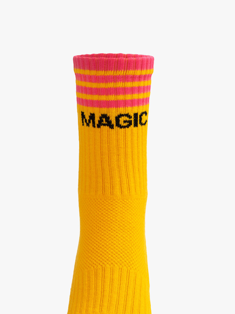 Front view of a deep yellow sock with dark pink stripes and the "MAGIC".