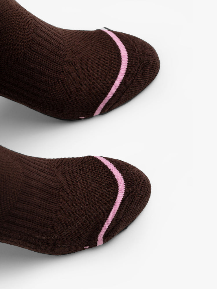 Toe detail view of a brown tube sock with pink stripe across toes