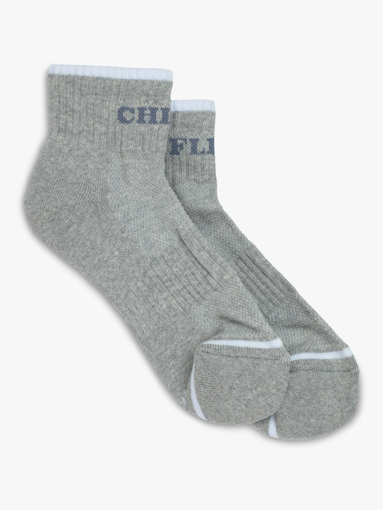 Top flat view of a pair of grey socks featuring light blue stripes and the words "CHICK" "FLICK".