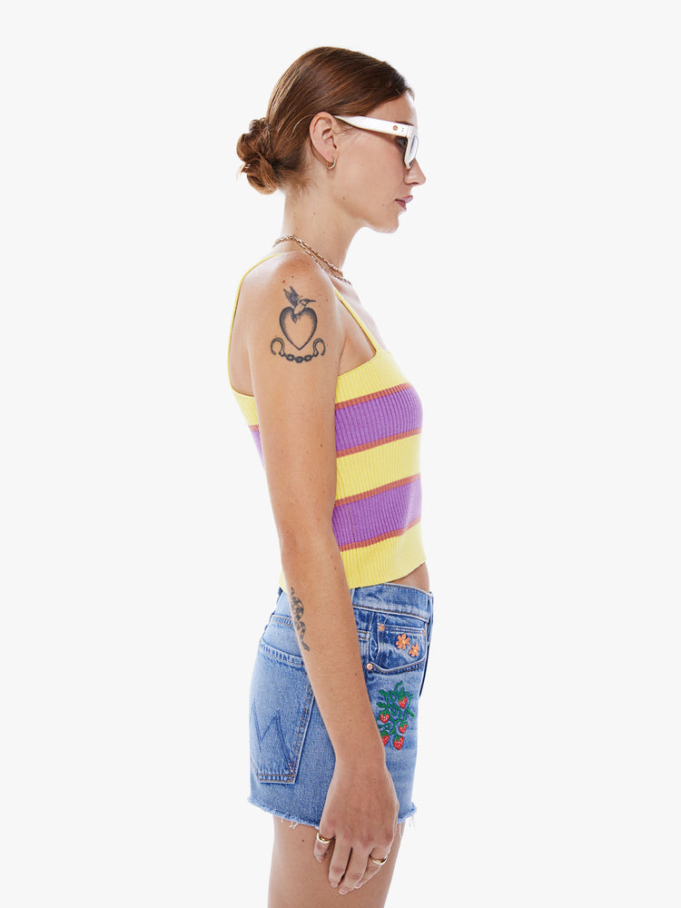 Side view of a woman cropped tube tank with a square neck, thin straps and a body-hugging fit in a purple and yellow stripe pattern.