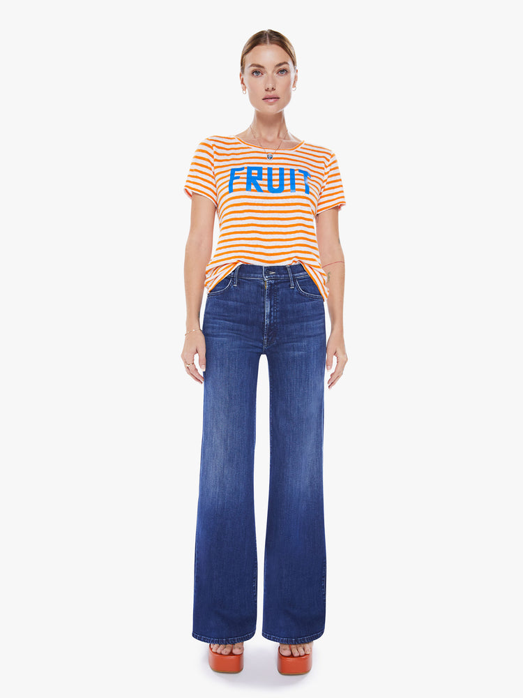 Full body view of a woman's boxy crewneck with short sleeves and a cropped hem in orange stripes and bright blue text.