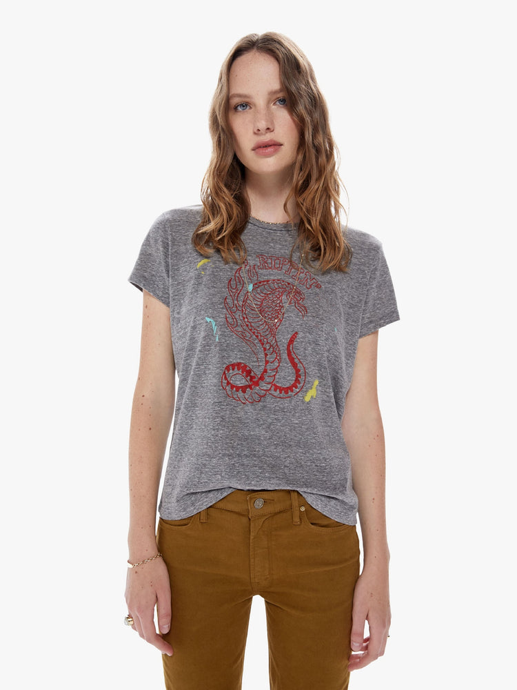 Front view of a woman in a soft crewneck with a slim fit for a vintage look and feel made from a cotton blend in a heathered grey hue, the tee features a faded cobra snake graphic in red and paint smears on the front
