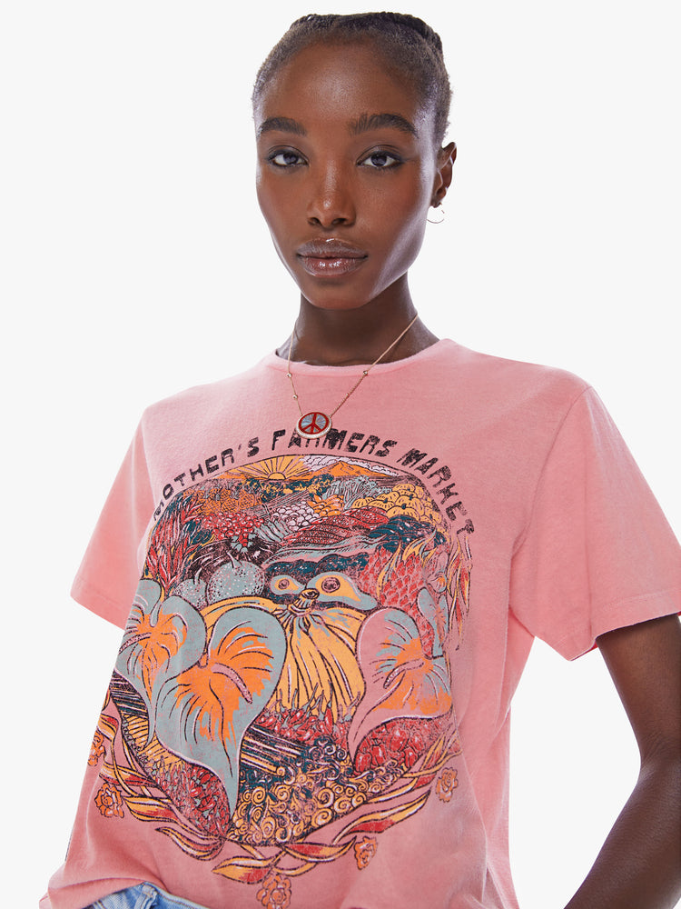 Close up view of a woman's crewneck tee with an oversized fit for a vintage look in a faded pink tee with colorful farmers market graphic.