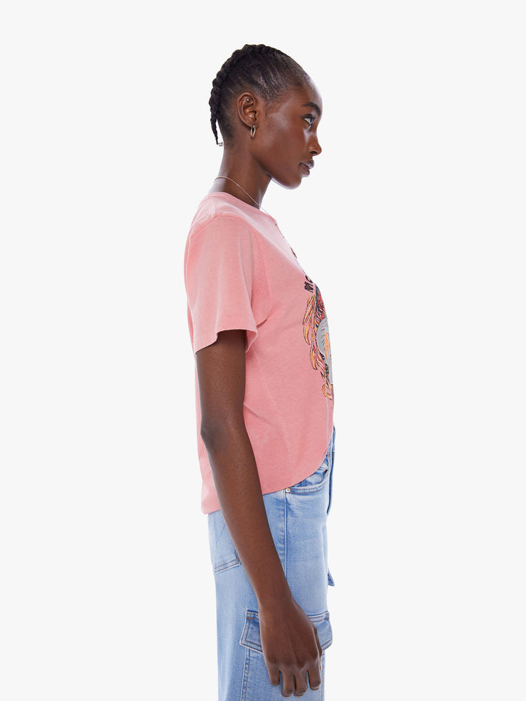 Side view of a woman's crewneck tee with an oversized fit for a vintage look in a faded pink tee with colorful farmers market graphic.