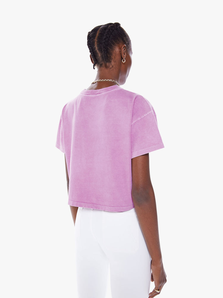Back view view of woman's cropped tee with a ribbed crewneck, drop shoulders and a boxy fit in a a washed fuchsia hue with white text.