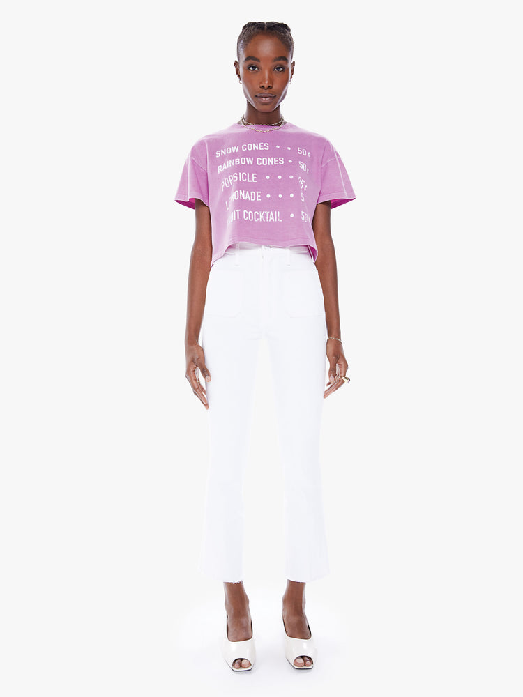 Full body view of a view of woman's cropped tee with a ribbed crewneck, drop shoulders and a boxy fit in a a washed fuchsia hue with white text.