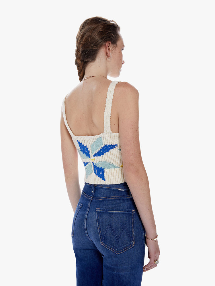 Back view of a woman knit top with a V-neck, thick straps and a cropped fit designed in an off-white hue with a colorful pinwheel motif on the front.