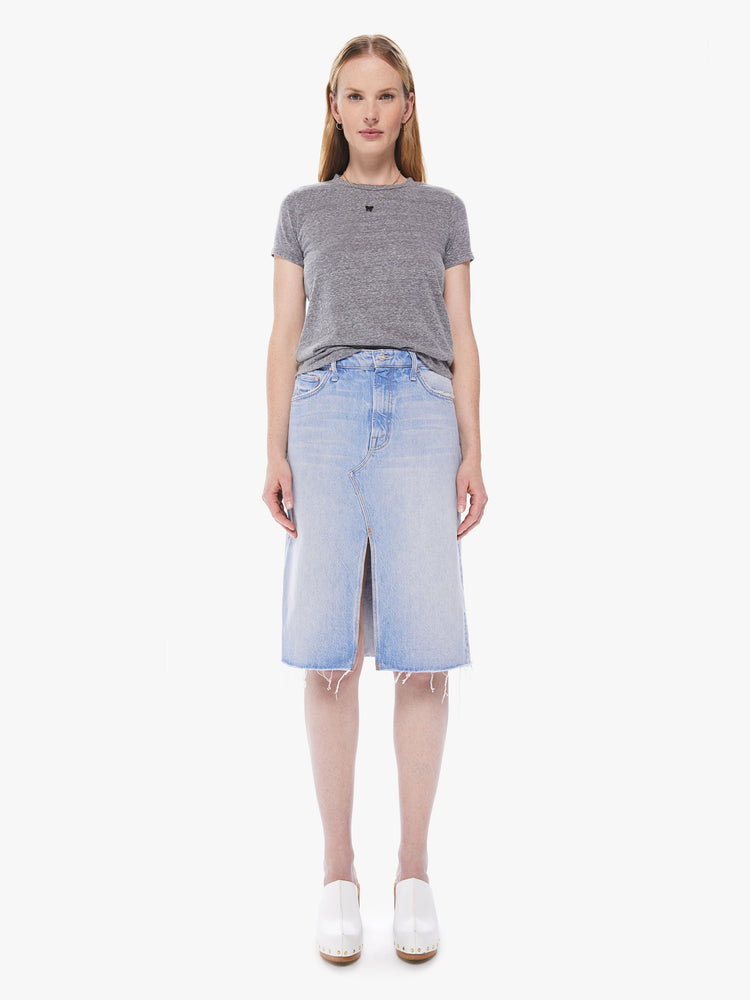Front view of a women's light blue denim midi skirt with a front slit and a frayed hem