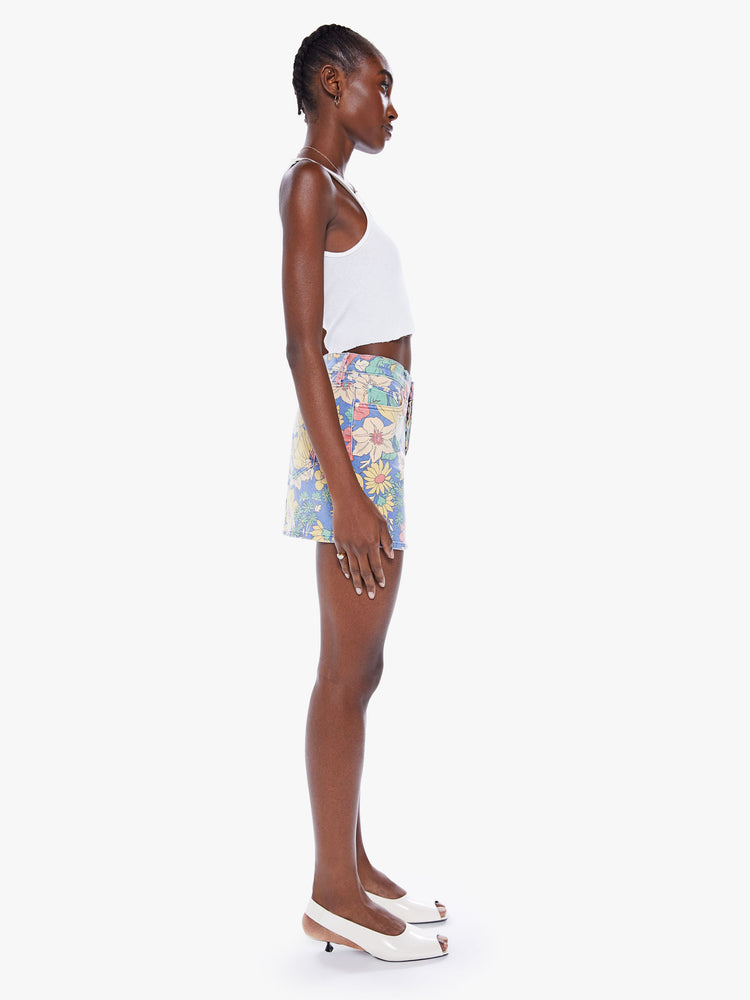 Side view of a woman denim mini skirt with a high rise, button-fly, slim fit and thigh-grazing hem in a faded floral print.
