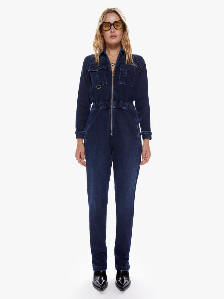 Front view of womens mechanic inspired zip up dark blue denim wash jumpsuit with collared neck, patch pockets, high rise elastic waistband and long sleeves.