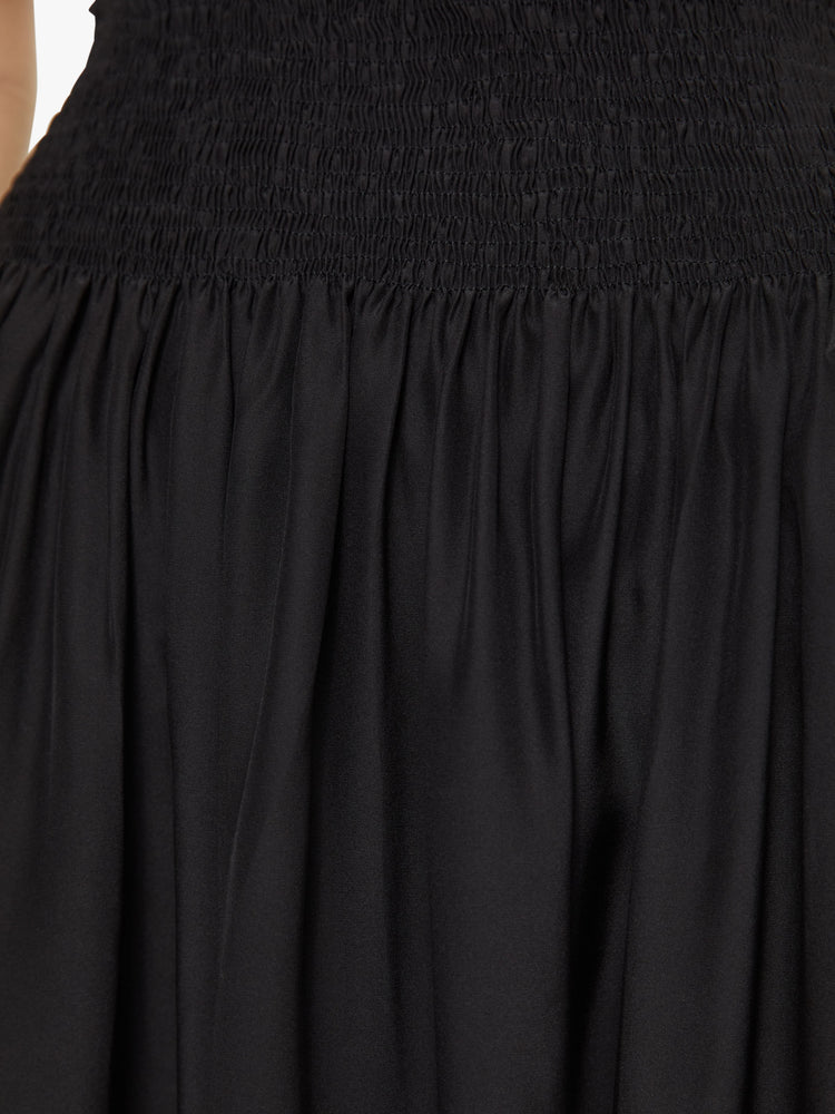 Front detail view of a black skirt with a shirred elastic waist.