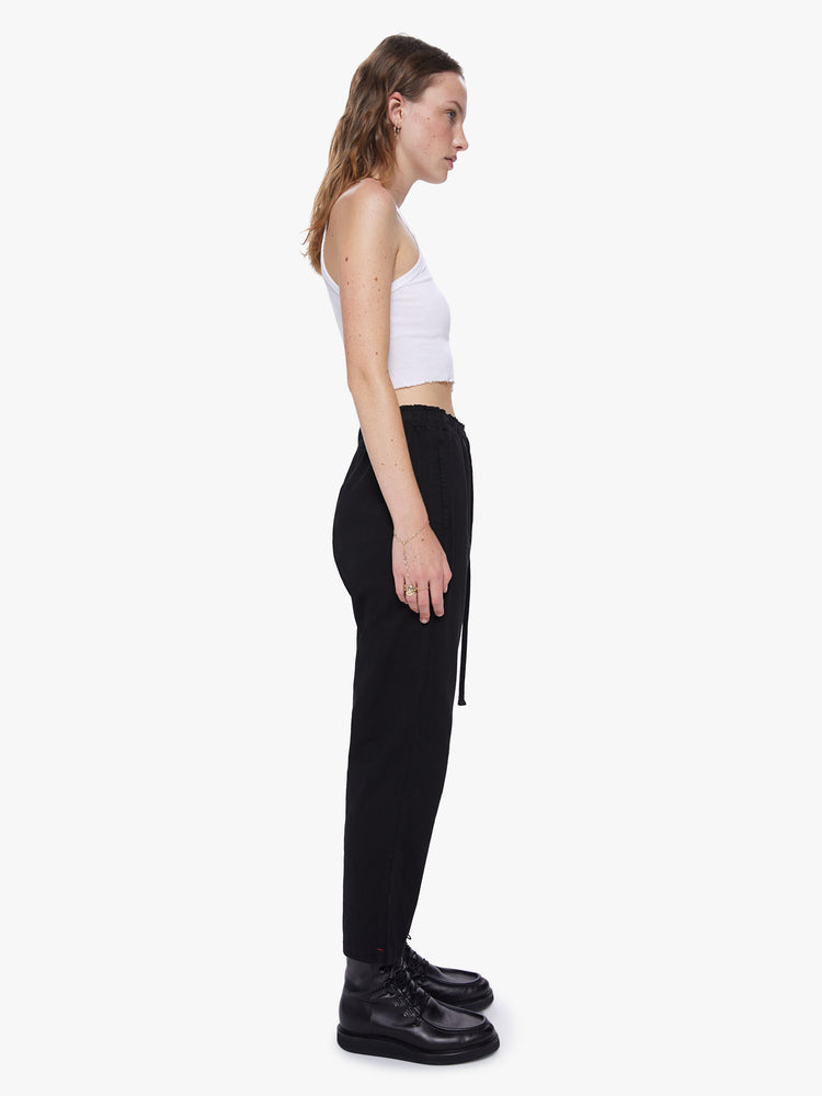 Side view of a womens high rise cotton pant featuring an elastic drawstring waist and a loose fit.