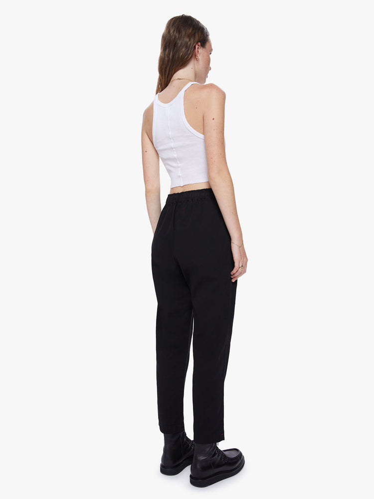 Back view of a womens high rise cotton pant featuring an elastic drawstring waist and a loose fit.